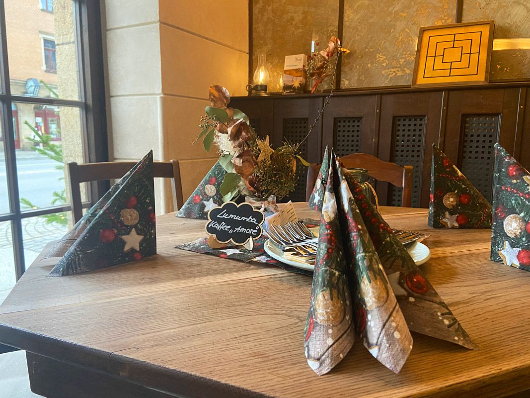 Tisch mit Weihnachtsdeko, im Hintergrund die Schauwand besehend aus alter Tapete