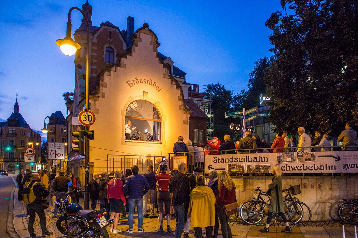 Das Braustübel im Abendlicht, aus dem Fenster schaut ein Musiker